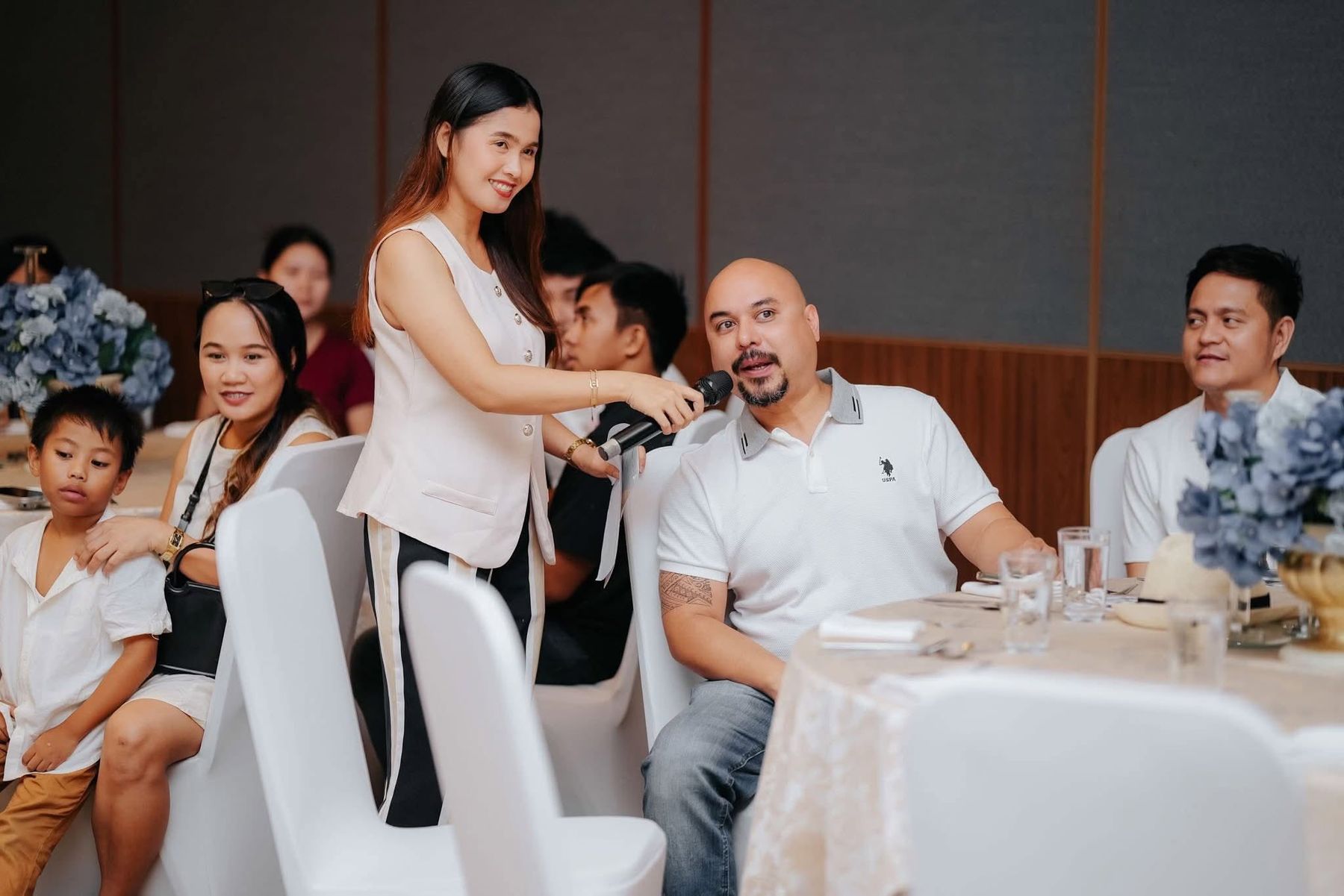 Host Mitch handing the microphone to a guest at his table