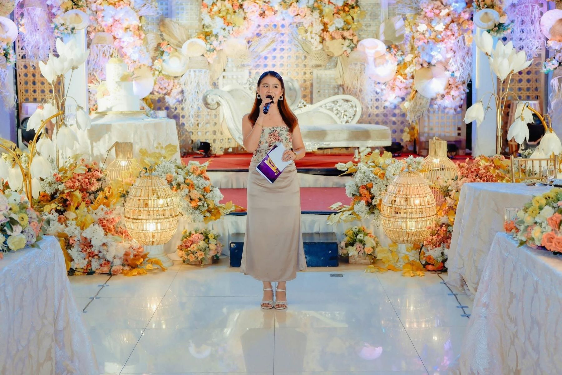 Host Mitch hosting in front of a floral wedding stage